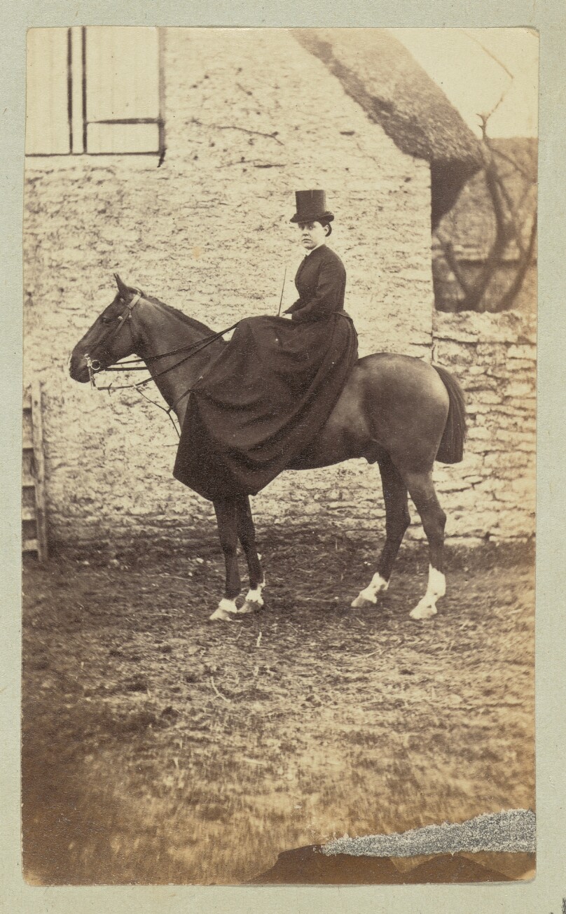 [Equestrian portrait of a woman in a dark dress and hat]