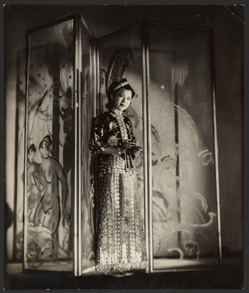 [Woman posed in front of screen with tea]