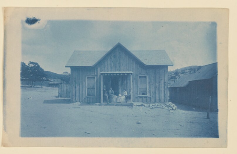 [Four figures and cabin]