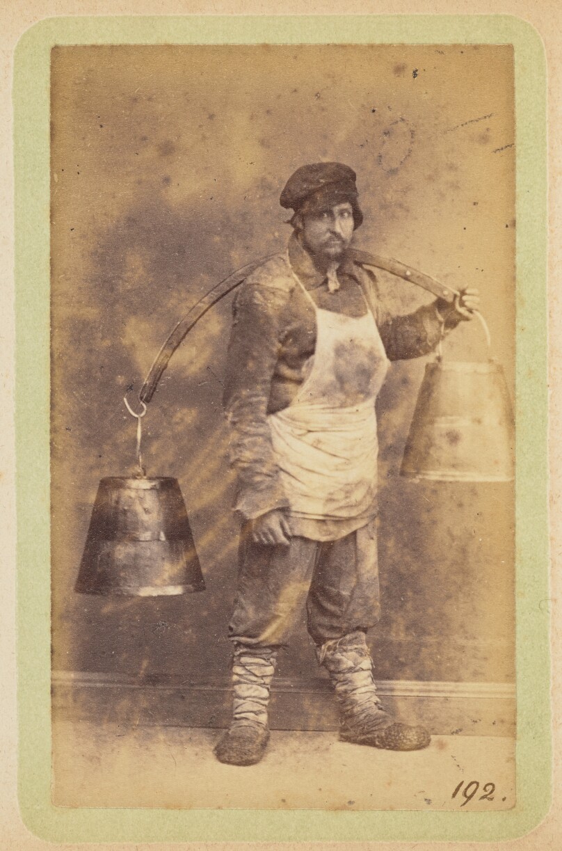 [Man carrying buckets on a yoke]
