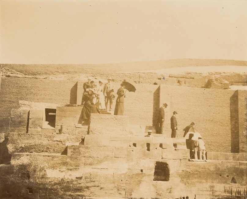 [Men and women standing on steps of ruin]