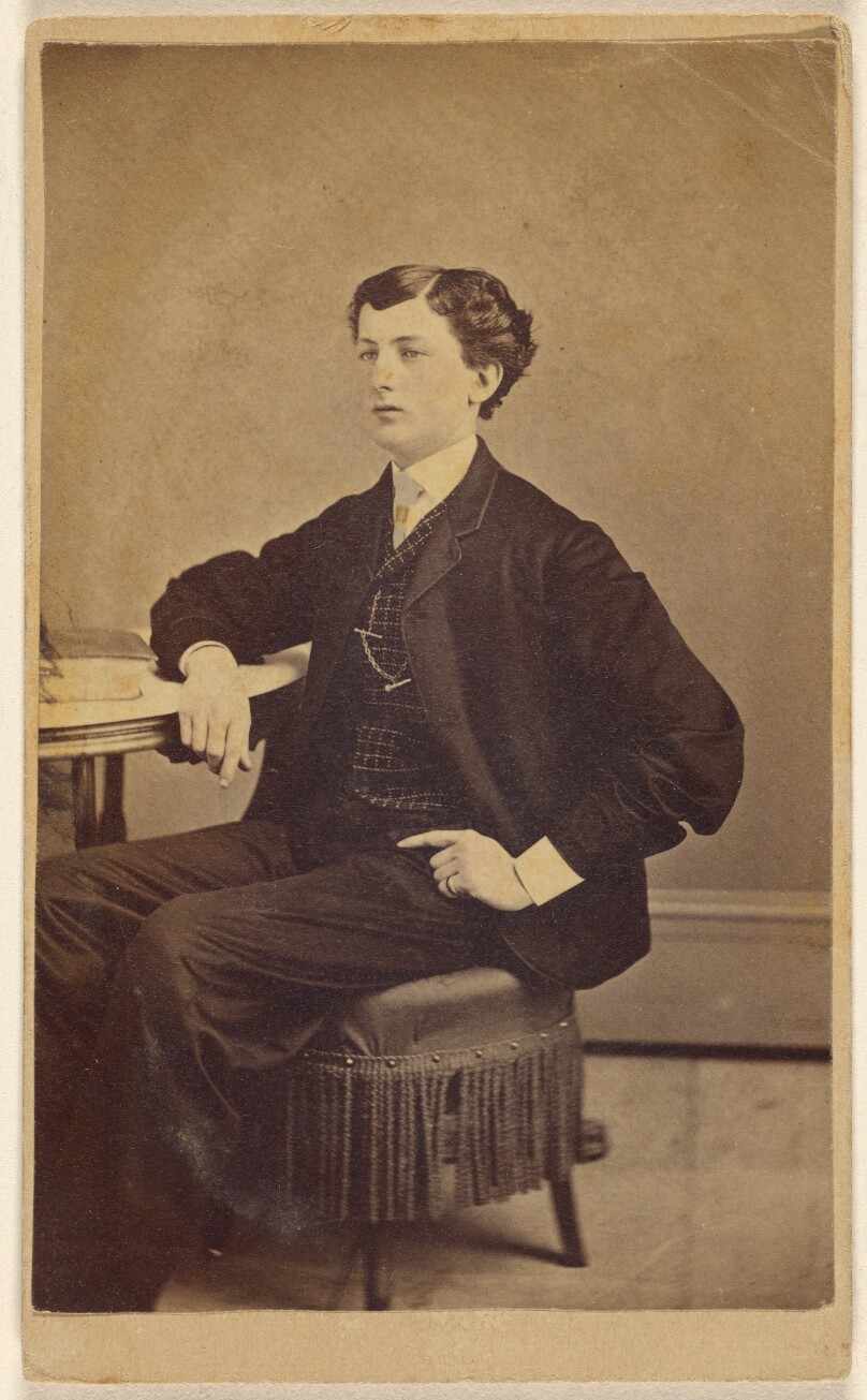 [Unidentified young man seated at a table]