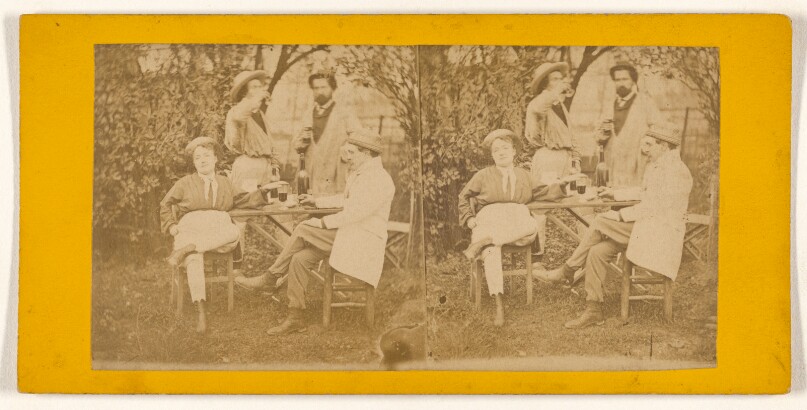 [Three men and a woman gathered around a table drinking]