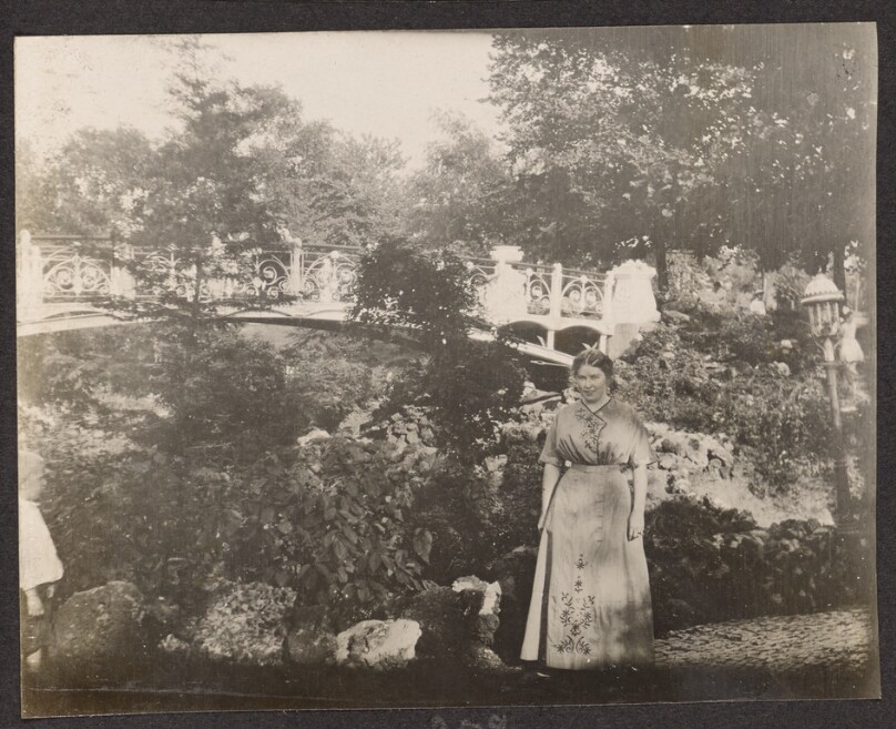 [Woman posing in front of a bridge]