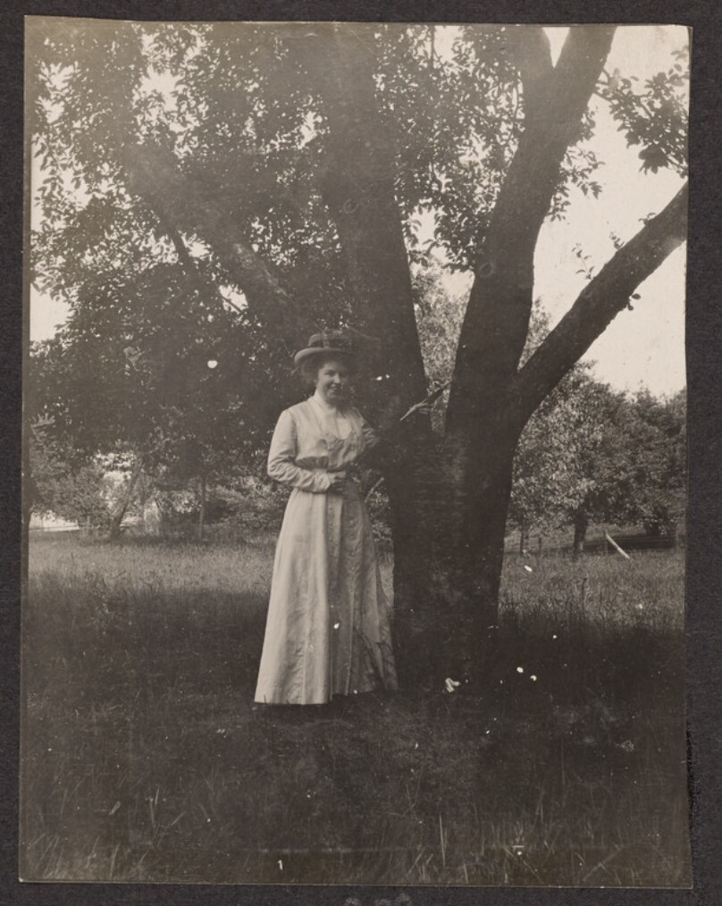 [Woman posing in front of a tree]