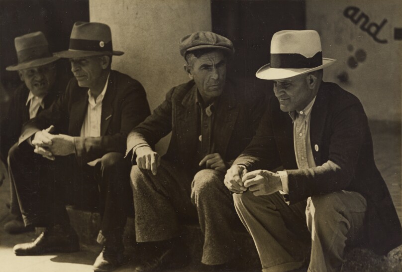 [Men sitting on a curb]