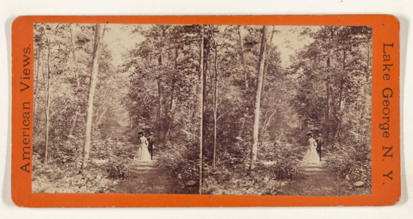 [Unidentified couple walking down a path in the woods, woman holding a parasol, at Lake George, New York]
