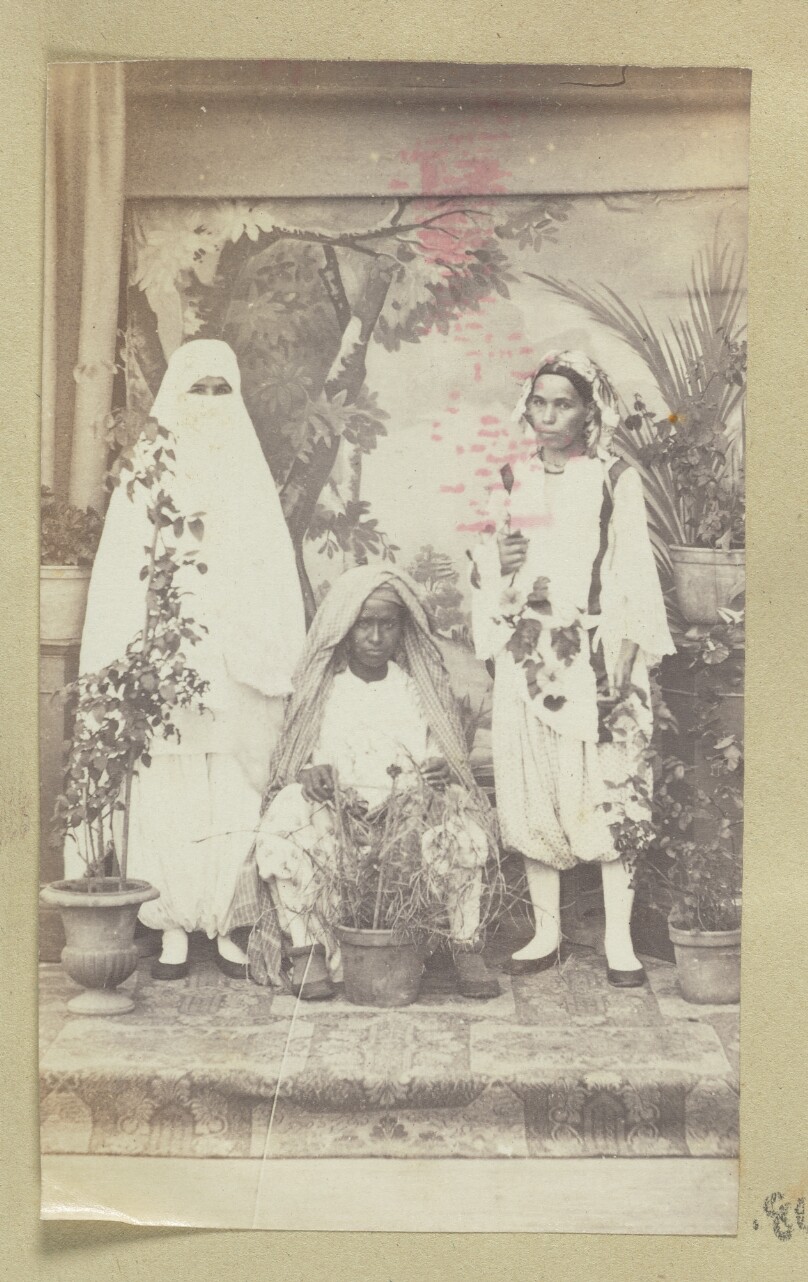 [Three people in Middle Eastern dress]