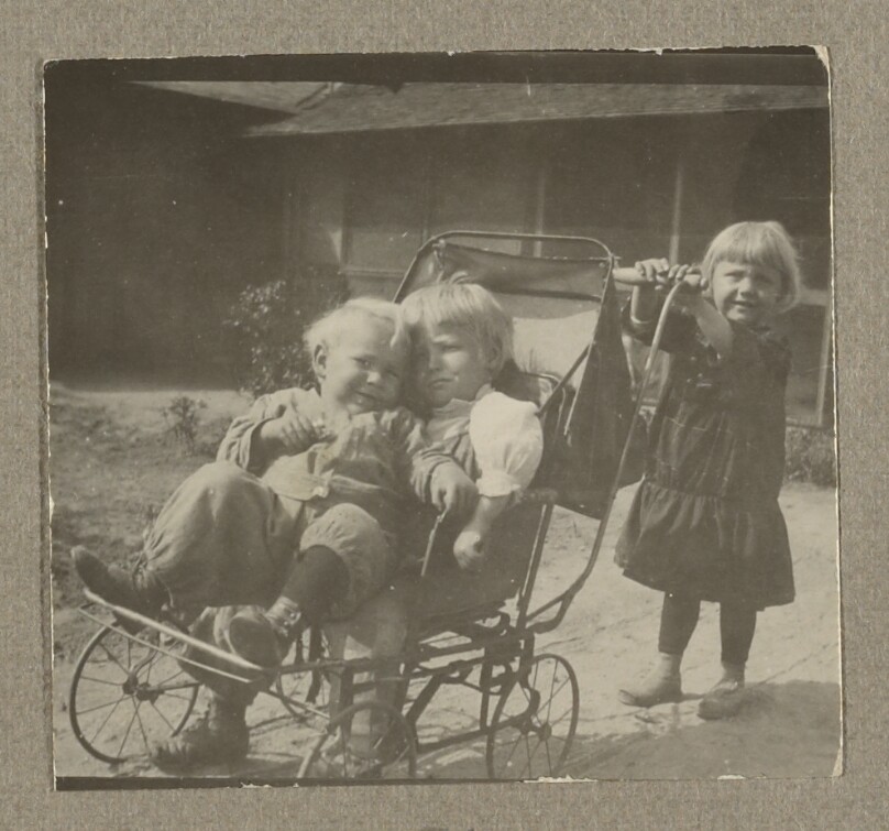 [Chandler Weston and an unidentified boy in baby carriage with a little girl pushing them]