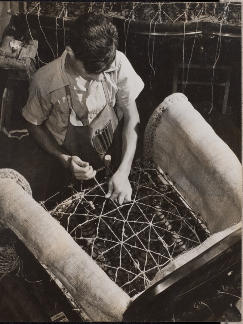 [Man adjusts seat coils for an armchair]