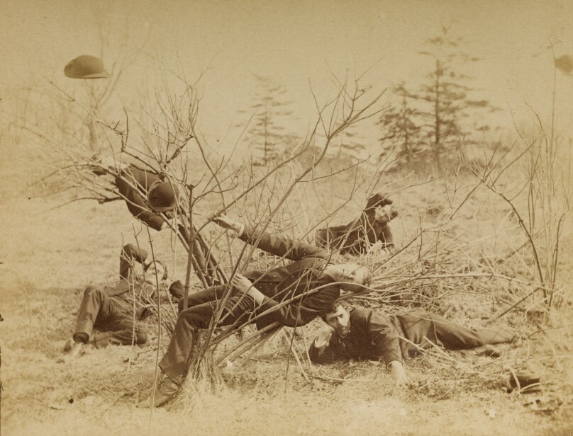 [Four male students reclining al fresco]