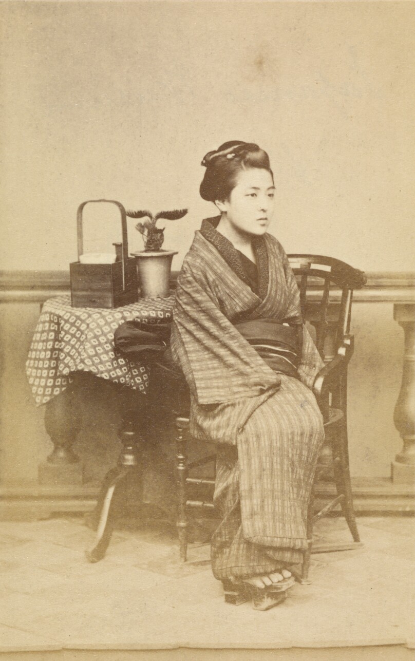 [Woman sitting by table]