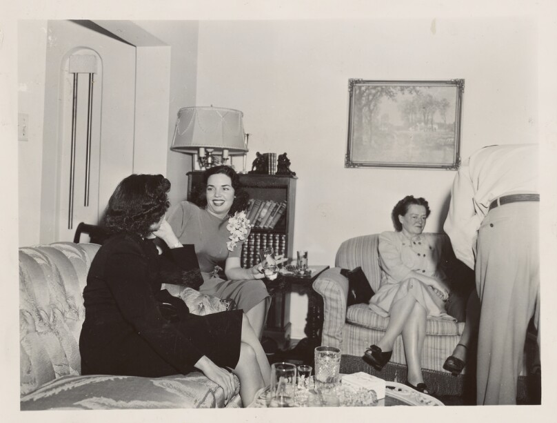 [Group drinking cocktails in sitting room]