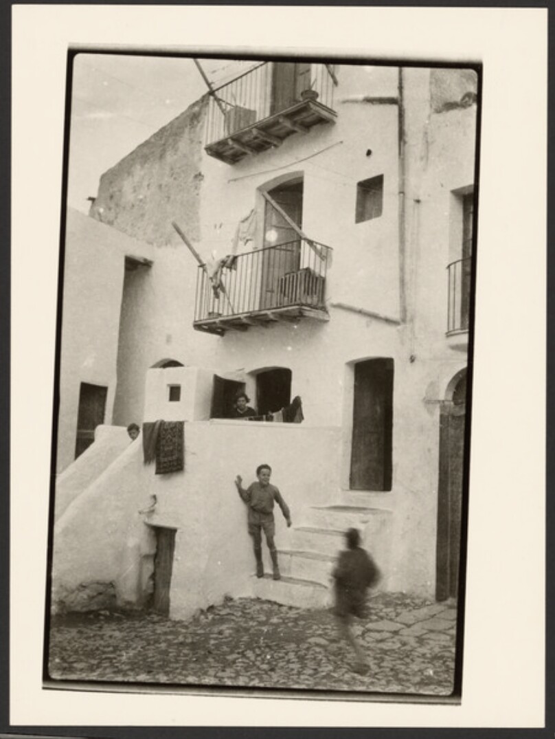 [Woman and children in front of house]