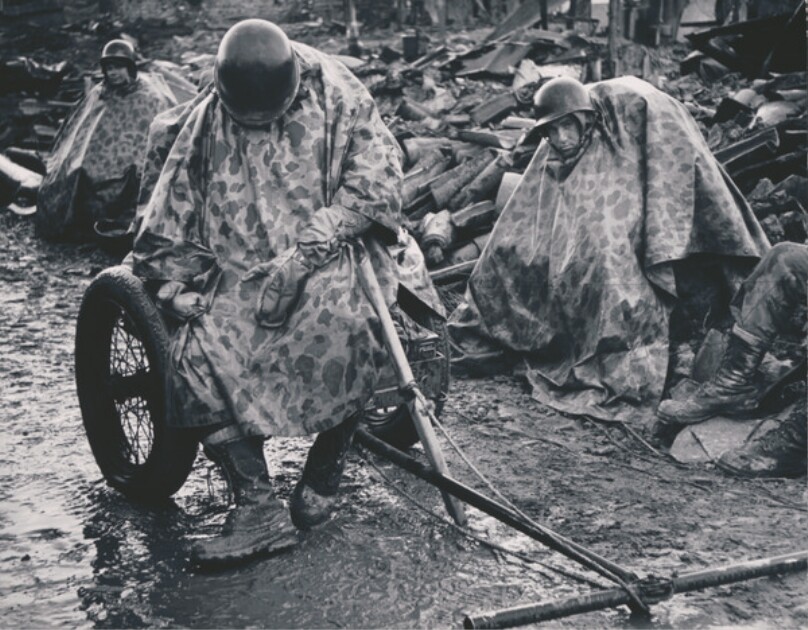 G.I.s shelter under their ponchos during the Korean War
