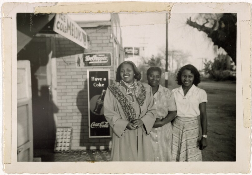 [Three women outside store]