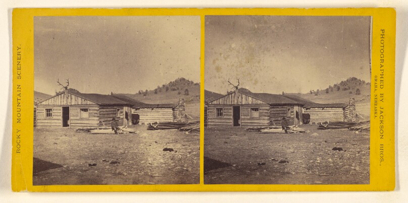 [Log cabin, man seated on woodpile at front, antlers at crest of roof]