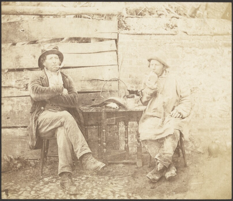 [Two Men Seated in Front of a Building]