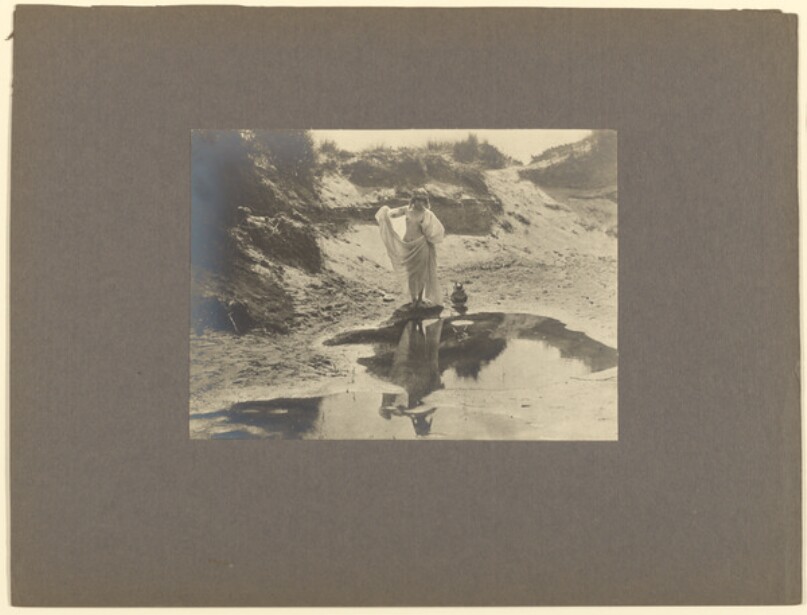 [Draped female nude on beach]