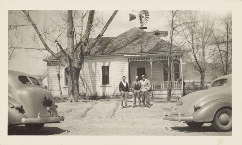 [Three men in front of house]
