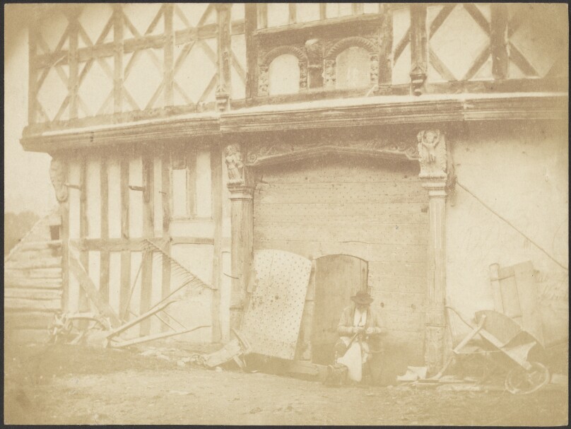 [Man Seated in Front of a Building]