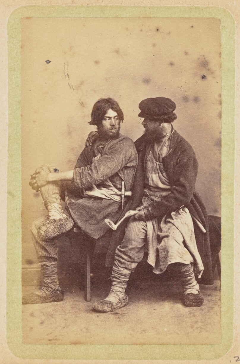 [Two men sitting on a bench]