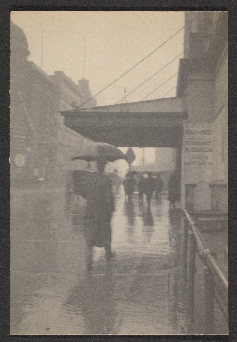 [Man with umbrella on rainy street]