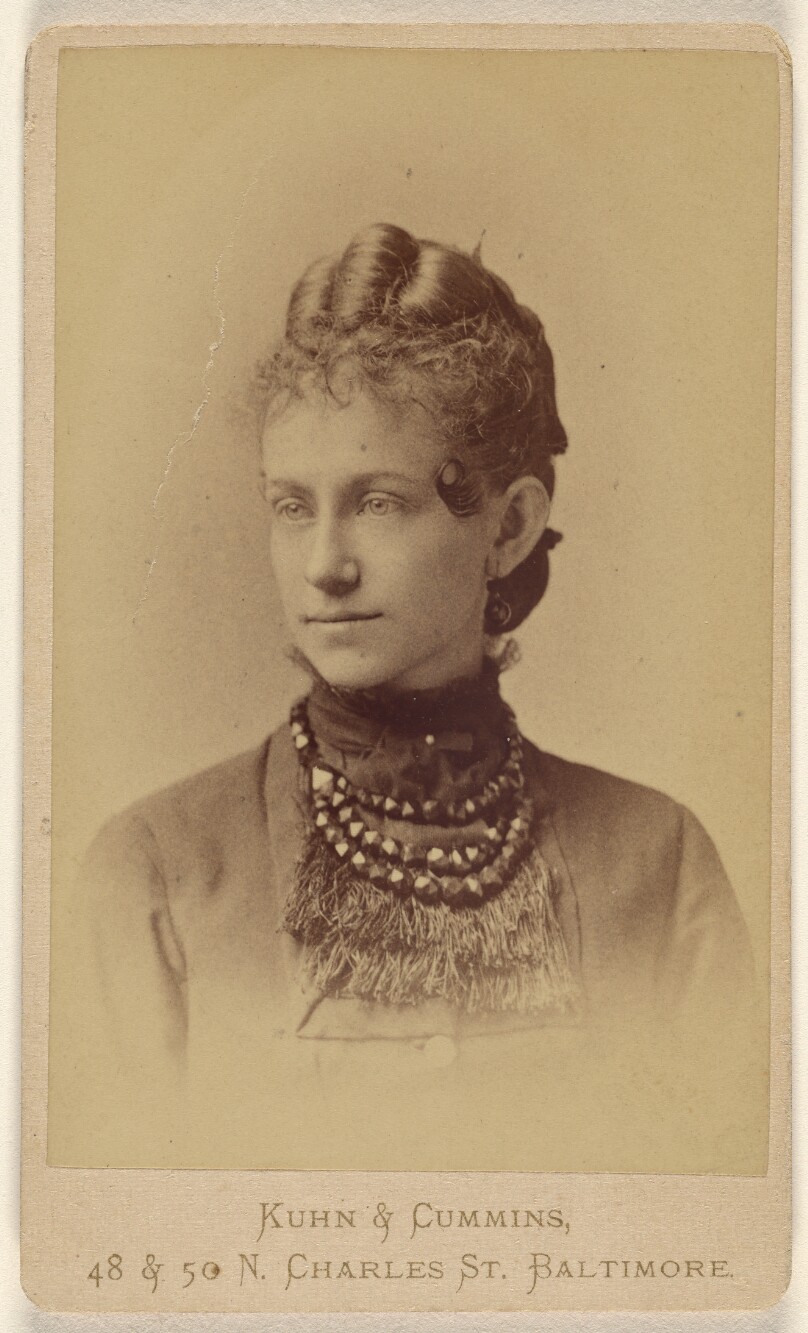 [Unidentified woman wearing a beaded and fringed necklace, printed in vignette-style]