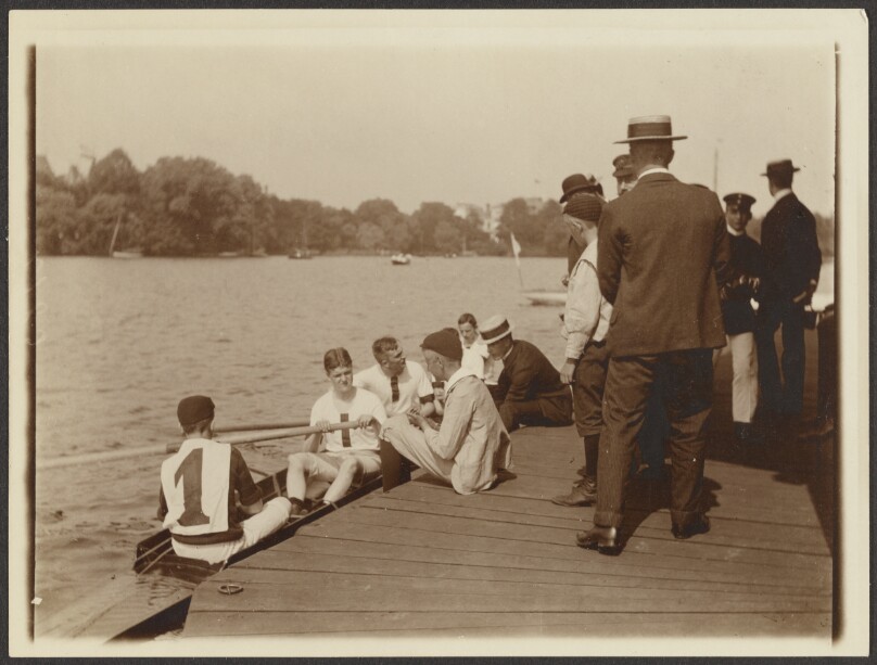 [Team of rowers at dock]