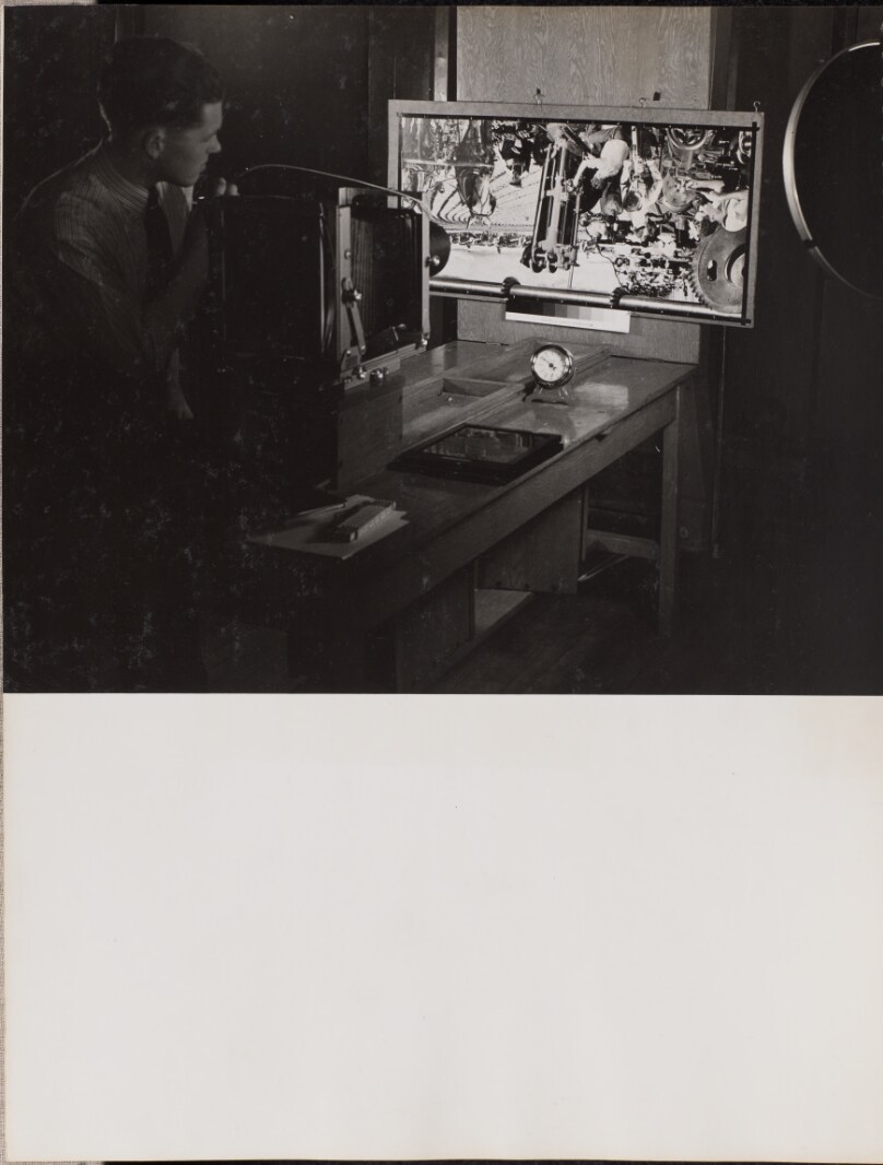 [Man adjusts a large-format camera with folding bellows]