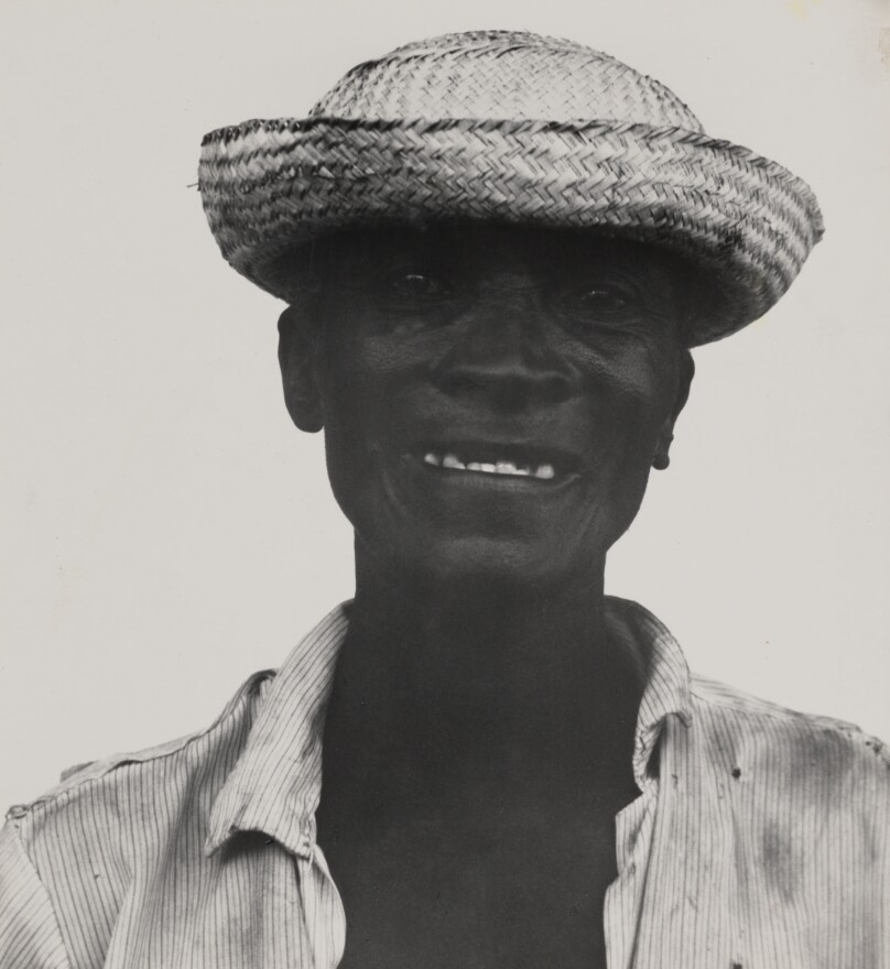 [Man in a straw hat and striped shirt]