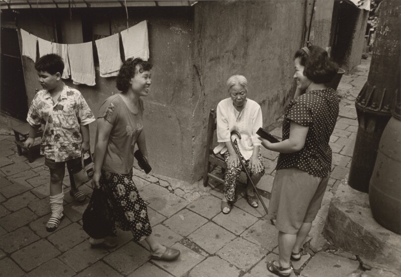 [Two Women Greeting Each Other at a Street Corner]