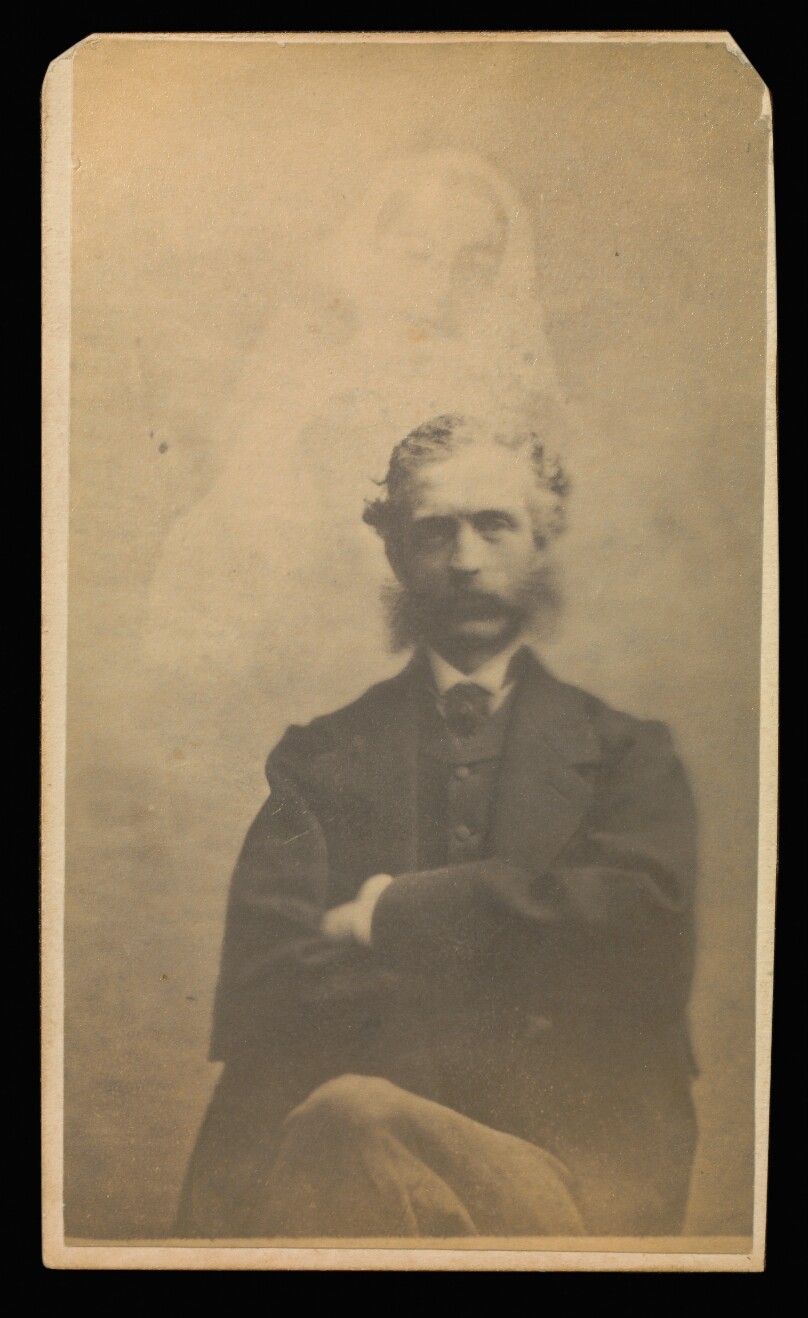 [Unidentified man with muttonchops seated with arms crossed, a female "spirit" in the background]