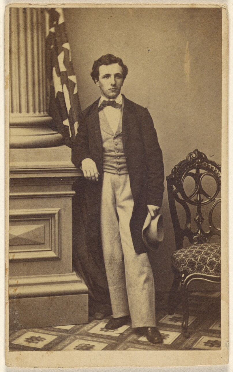 [Unidentified man holding a hat, standing]