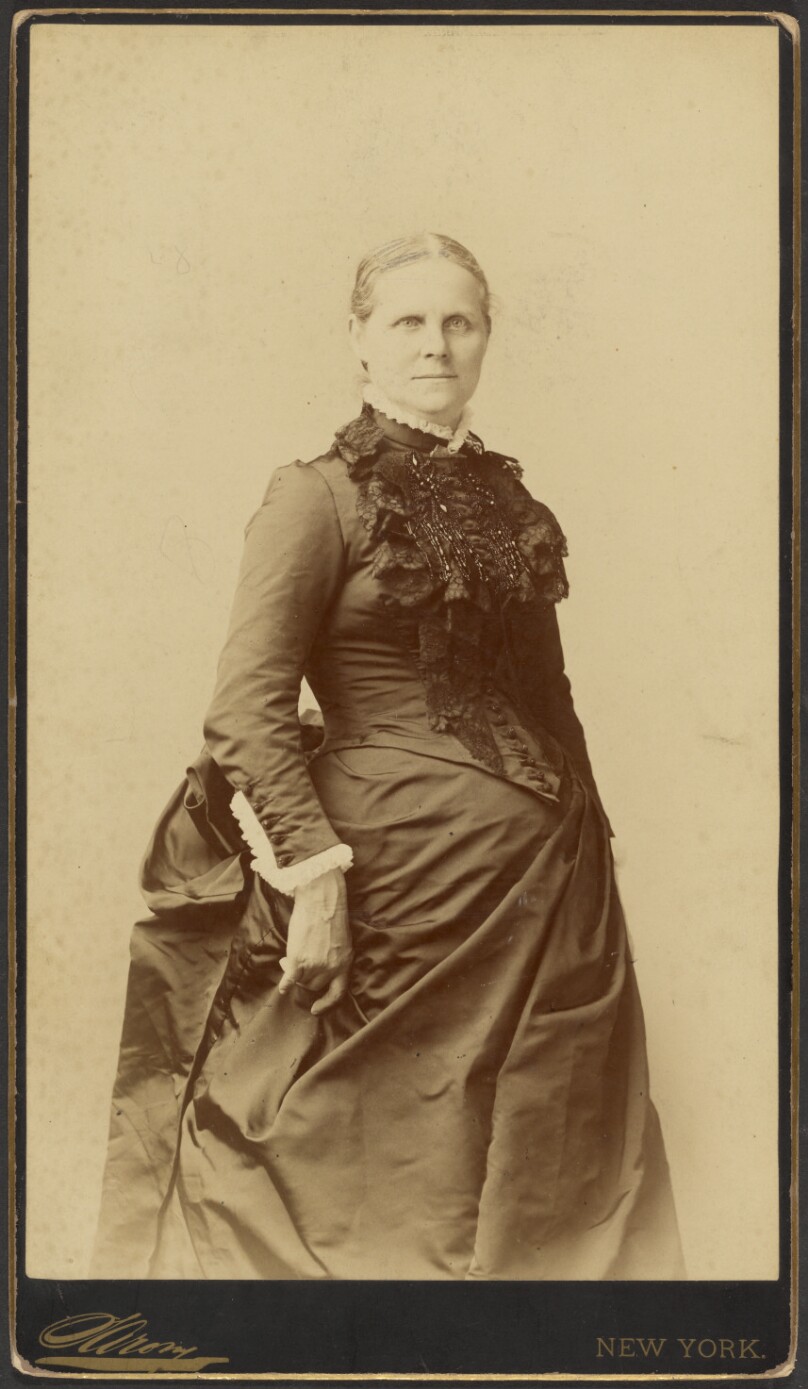 [Unidentified woman in long dress standing]