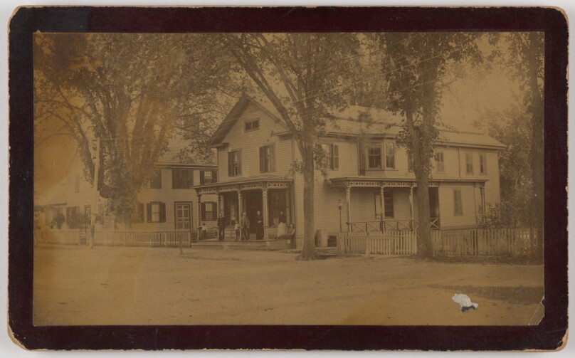 [Long view of house with family on front porch]