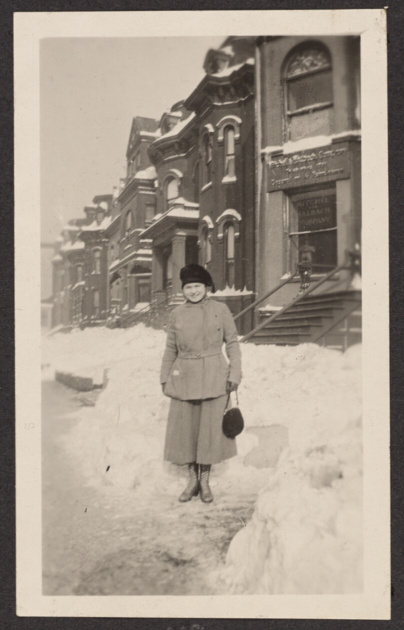 [Woman standing on a snowy sidewalk]