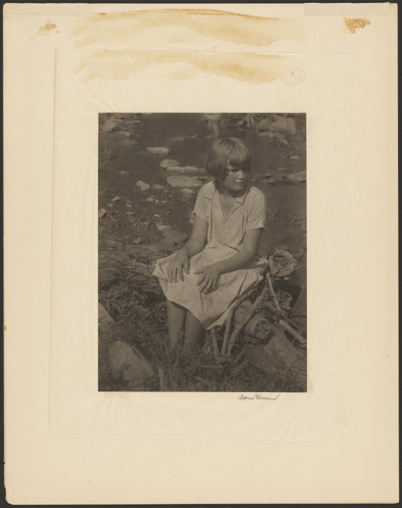 [Girl Sitting on Log by Creek]