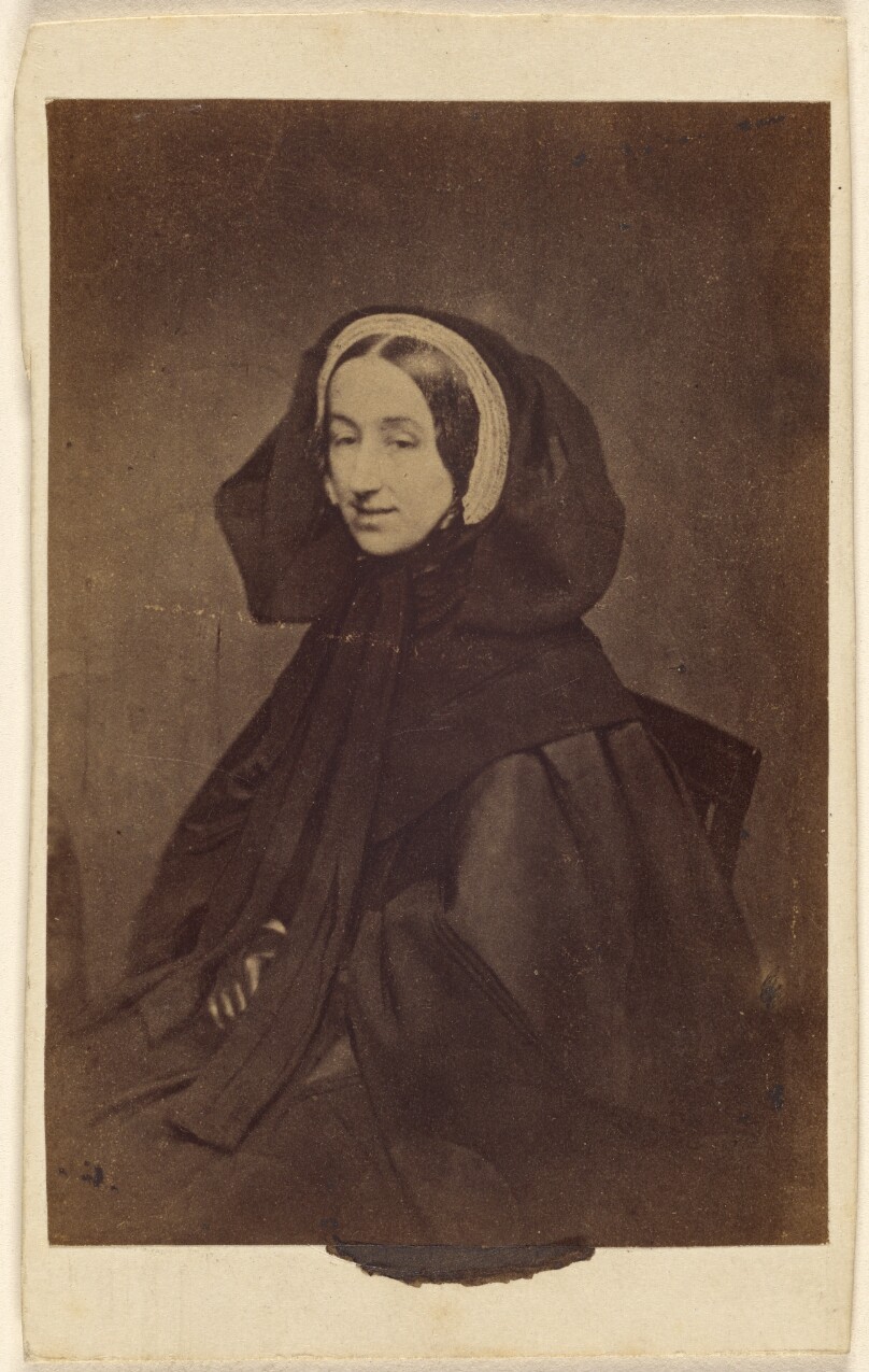 [Unidentified woman dressed in all dark clothes, seated]