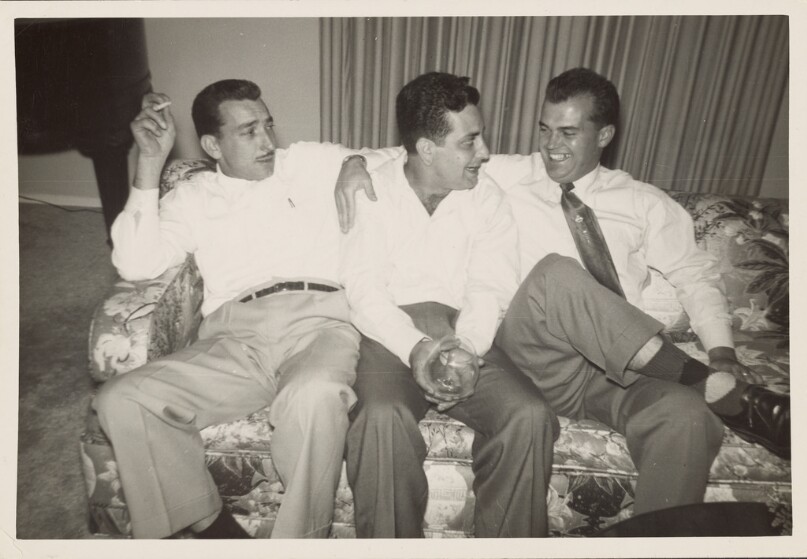 [Three men seated on couch]