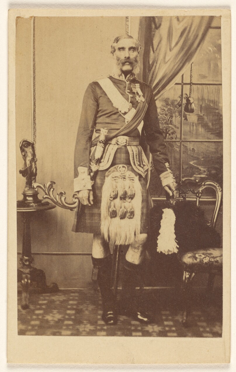 [Unidentified bearded man with metals on chest, wearing kilt, standing]