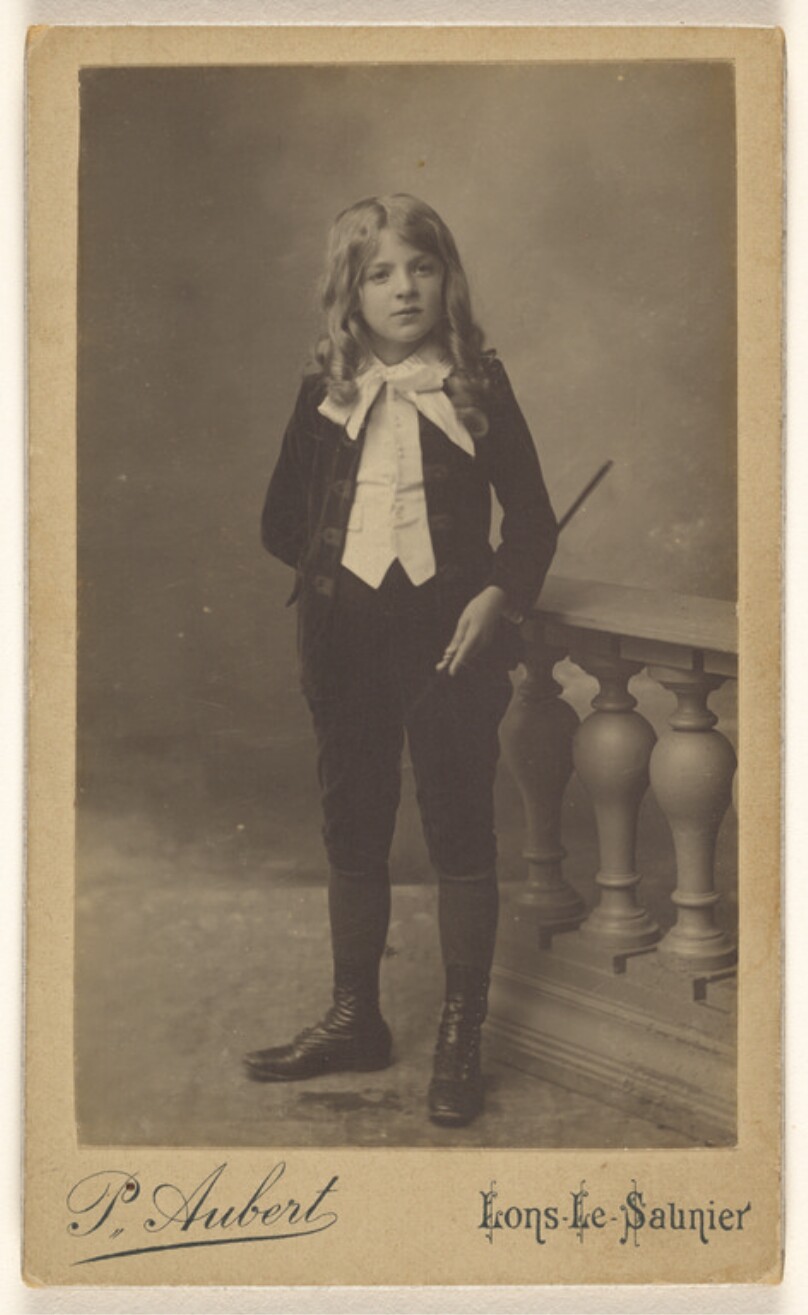 [Unidentified child, holding a baton, standing]
