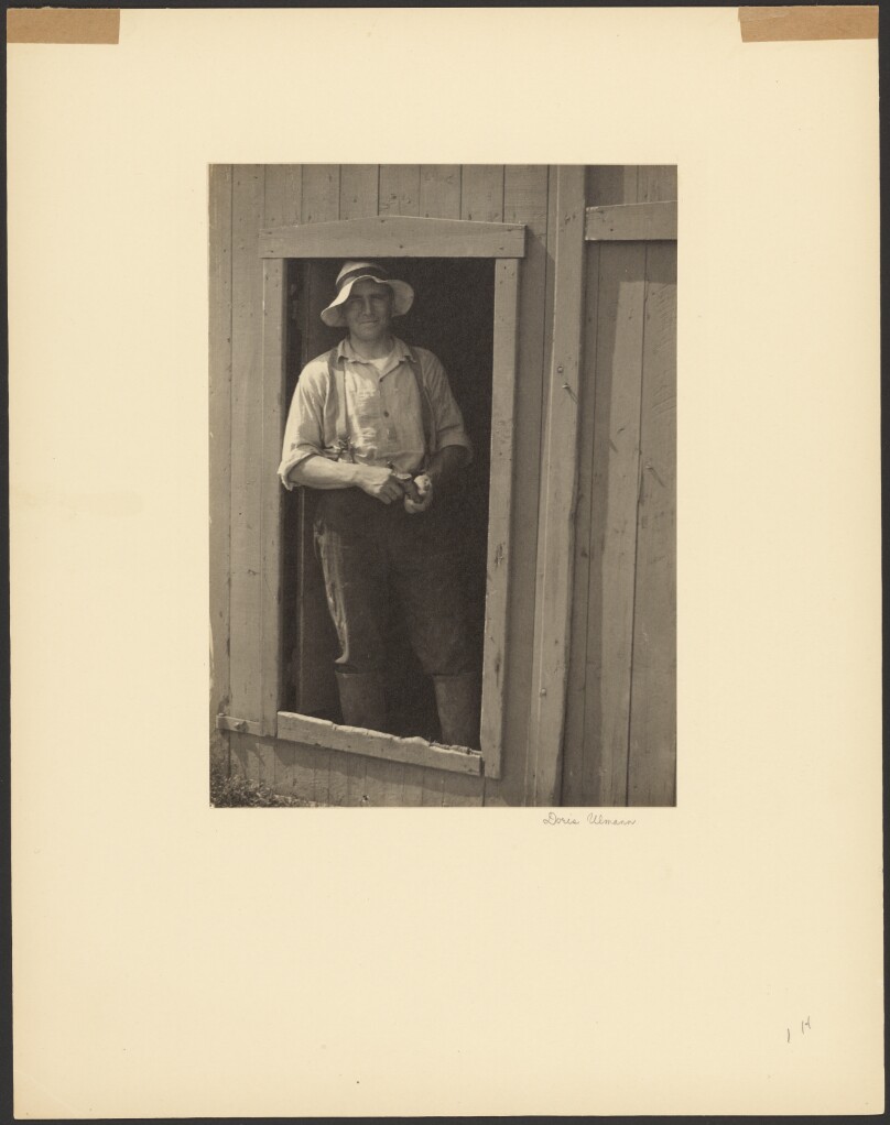 [Man in a Straw Hat Standing in Doorway of a Barn Holding a Tobacco Pouch]