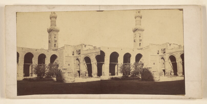 [View of building with high tower, tomb in courtyard]