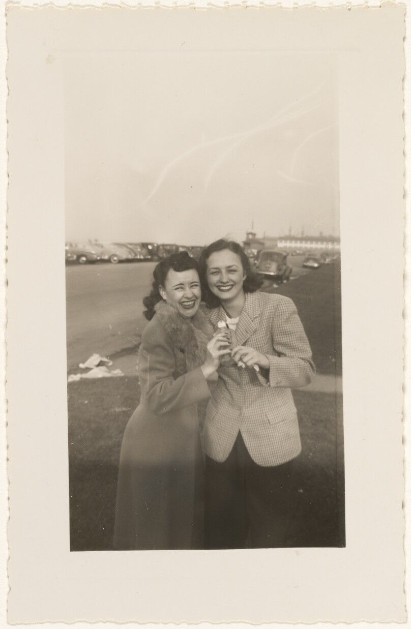 [Two women holding a bottle]