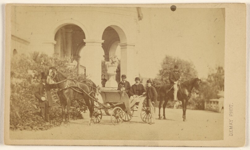 [Two unidentified men in a horse-drawn carriage, plus three other men at horse, carriage and archway, at Aix-les-Bains, France]