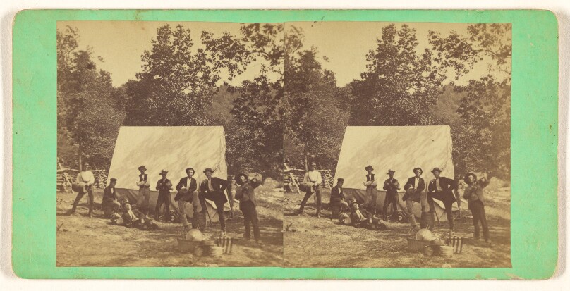 [Group of men posed in front of a tent]