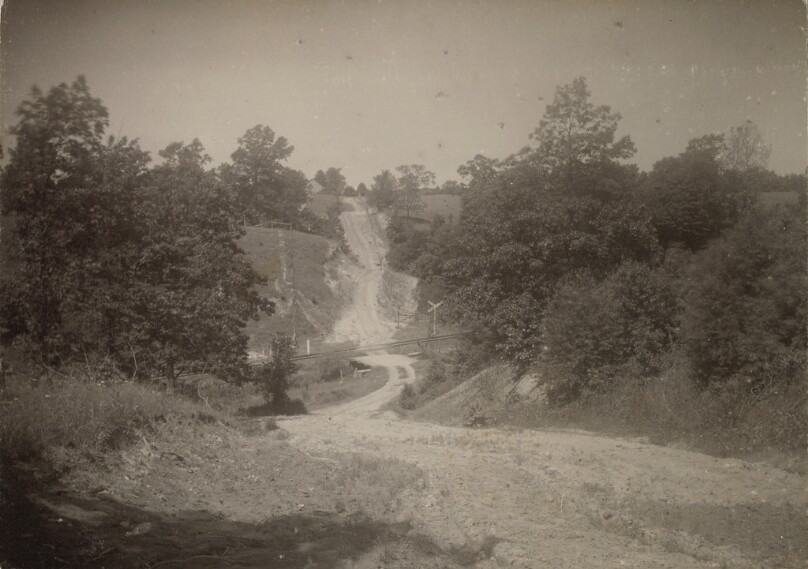 [Landscape with dirt road and railway crossing]