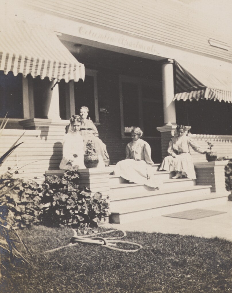 [Women sitting on porch steps]