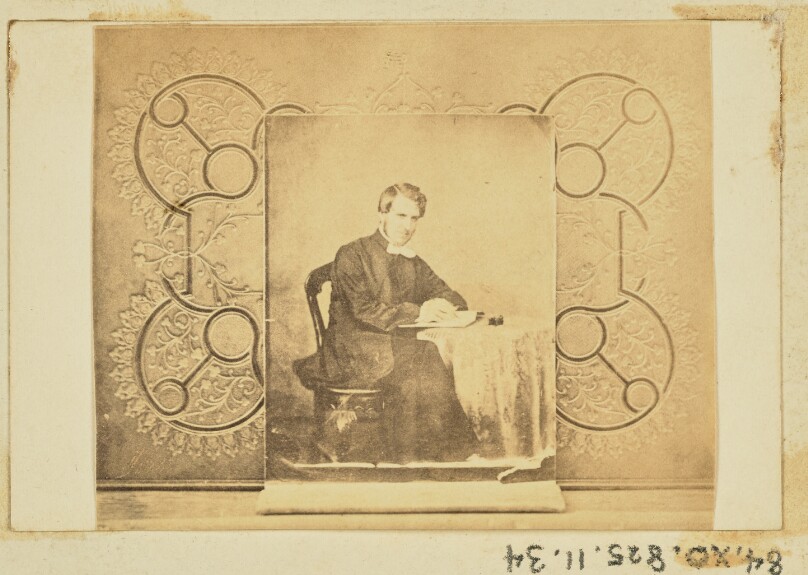 [Portrait of a man seated at a table]